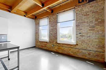 A room with a brick wall and a table.